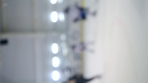 背景がぼやけている ホッケー選手のチームはホッケーをプレイ 少年たちはアイススタジアムでアイスリンクでホッケーをする アイスホッケーの試合選手権スポーツスケート競技リアルプロのゲーム垂直ビデオ — ストック動画