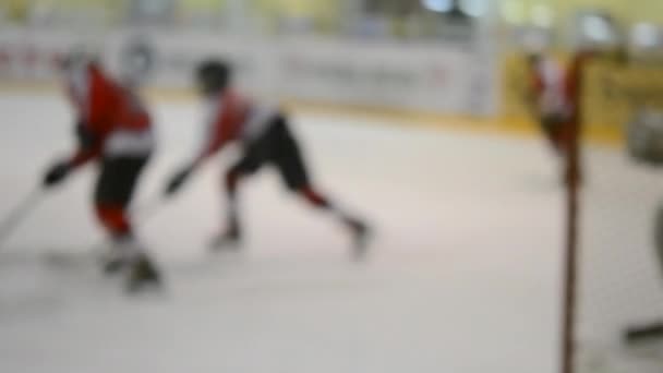 背景がぼやけている ホッケー選手のチームはホッケーをプレイ 10代の男の子は屋内のアイススタジアムでアイスリンクでホッケーをします アイスホッケーの試合選手権スポーツスケート競技 レアル プロの試合 — ストック動画