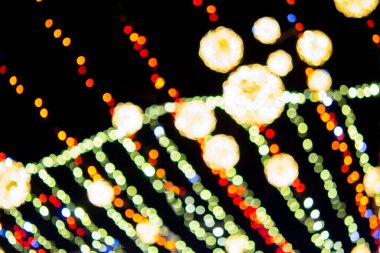 New Years Christmas tree decorated with luminous multi-colored garlands and illumination at night. Christmas tree with flashing lights. Blurred background. New Year Christmas holidays.