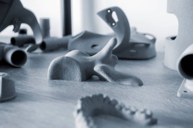 Toz 3D yazıcıya yakın planda basılmış insan kemiğinin prototip parçası. Polyamide tozundan üç boyutlu yazıcıya basılmış figür. Çoklu Jet Füzyon MJF. Yeni katkı maddesi modern 3D yazıcı teknolojisi