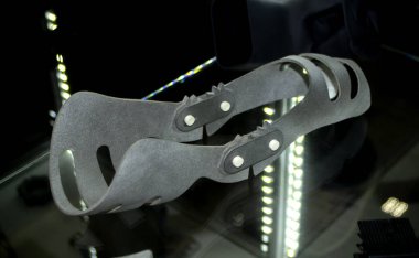 Gray orthopedic plastic prosthesis printed on powder 3D printer for cubit hand. Orthopedic gypsum helmet closeup. Multi Jet Fusion MJF 3D printing technology. New modern progressive additive technolog