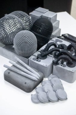 3D yazıcıda birçok farklı model basıldı. Plastikten yapılmış 3 boyutlu yazıcıya basılmış gri ve siyah nesneler. Bir sürü 3D baskı modeli. Masadaki 3D yazıcı tarafından yapılan çeşitli şekillerin prototipleri.