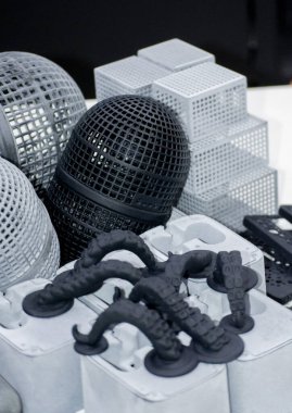 3D yazıcıda birçok farklı model basıldı. Plastikten yapılmış 3 boyutlu yazıcıya basılmış gri ve siyah nesneler. Bir sürü 3D baskı modeli. Masadaki 3D yazıcı tarafından yapılan çeşitli şekillerin prototipleri.