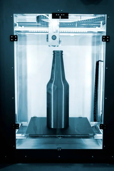 Object green bottle printed on 3D printer close-up, inside on desktop of 3d printer. Progressive modern additive technology. Concept 4.0 industrial revolution. Modern 3D printing additive technology