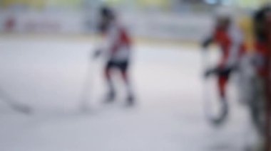 Arka plan bulanık. Hokey oynayan hokey oyuncuları. Genç çocuklar buz pateni pistinde buz pateni oynuyorlar. Buz hokeyi şampiyonası spor buz pateni yarışmaları Gerçek profesyonel oyun