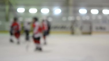 Arka plan bulanık. Hokey oynayan hokey oyuncuları. Genç çocuklar buz pateni pistinde buz pateni oynuyorlar. Buz hokeyi şampiyonası spor buz pateni yarışmaları Gerçek profesyonel oyun