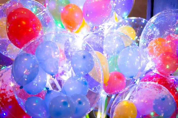 Balloons with luminous garland inside. Abstract colorful background. Many different colorful balloons with a flashing garland inside close-up. Concept holiday, festival, celebrate, New Year, Christmas