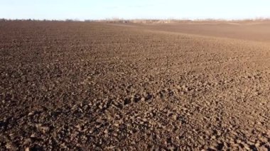 Flying over the plowed fields of black soil on sunny autumn day. Fields black soil close-up. Farming countryside rural. Digged agrarian agricultural earth fields. Plowed lands. Dug up ground farmlands