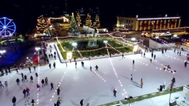 Kyiv, Ukrayna 20 Ocak 2022: İnsanlar açık havada güzel buz pateni pistlerinde kayıyorlar. Yeni yıl süsleri, dekorasyonlar, kış gecelerinde parlak çelenkler. Yeni yıl Noel 'i