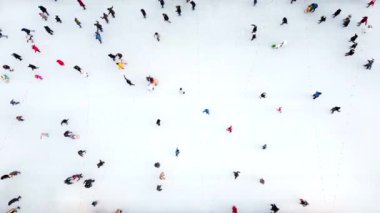Birçok insan kış günü açık havada beyaz buz pateni pistinde paten kayıyor. Hava aracı görüntüsü. Yeni yıl Noel kutlaması tatil eğlence sporu yaşam tarzının eğlenceli arka planı.