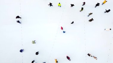 Birçok insan kış günü açık havada beyaz buz pateni pistinde paten kayıyor. Hava aracı görüntüsü. Yeni yıl Noel kutlaması tatil eğlence sporu yaşam tarzının eğlenceli arka planı.
