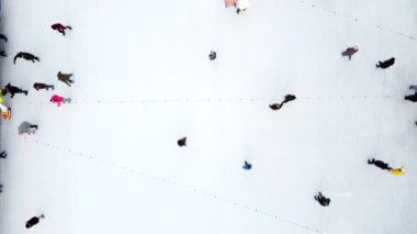 Birçok insan kış günü açık havada beyaz buz pateni pistinde paten kayıyor. Hava aracı görüntüsü. Yeni yıl Noel kutlaması tatil eğlence sporu yaşam tarzının eğlenceli arka planı.