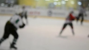 Arka plan bulanık. Hokey oynayan hokey oyuncuları. Genç çocuklar buz pateni pistinde buz pateni oynuyorlar. Buz hokeyi şampiyonası spor buz pateni yarışmaları Gerçek profesyonel oyun