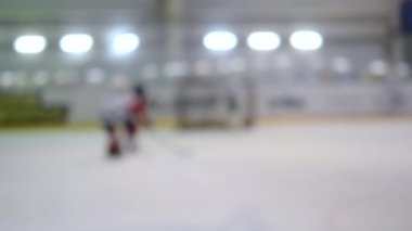 Arka plan bulanık. Hokey oynayan hokey oyuncuları. Genç çocuklar buz pateni pistinde buz pateni oynuyorlar. Buz hokeyi şampiyonası spor buz pateni yarışmaları Gerçek profesyonel oyun