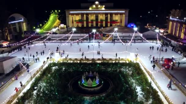 キエフ ウクライナ1月20 2022 人々は屋外で美しいアイススケートリンクでスケート冬の夜にクリスマスのイルミネーション 装飾品 明るいガーランドを飾られました 新年のクリスマス — ストック動画