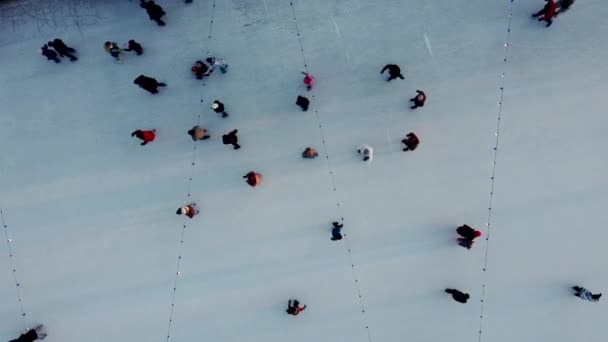 许多人在冬日落山时在露天溜冰场上滑冰 顶部视图 空中无人驾驶飞机视图 休闲活动 生活方式 享受乐趣背景 色彩斑斓的背景 — 图库视频影像