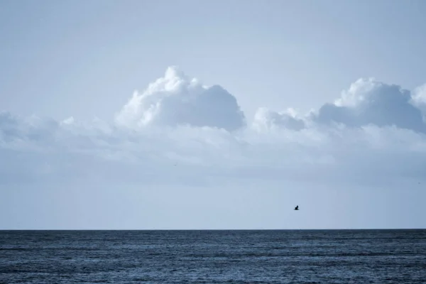 Λευκά Πυκνά Σύννεφα Πάνω Από Την Μπλε Επιφάνεια Της Θάλασσας — Φωτογραφία Αρχείου