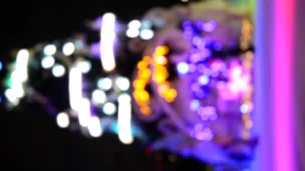 多くの人がオープンエアのアイススケートリンクでスケートし 大きなクリスマスツリーは 冬の夜に多色の明るい装飾 ガーランド 装飾を装飾しました 抽象的な背景がぼやけている 垂直ビデオ — ストック動画