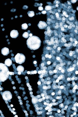 Yılbaşı ağacı çok renkli çelenkler ve gece aydınlatmalarla süslenmiş. Yanıp sönen ışıkları olan Noel ağacı. Arka plan bulanık. Yılbaşı tatili. Mavi renk