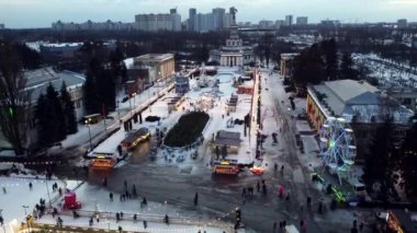 Kyiv, Ukrayna 20 Ocak 2022: Birçok insan Noel ağacı, farklı binalar, gıda sahası, açık hava buz pateni pisti ve kış gecelerinde yılbaşı süsleriyle parkta yürüyor.