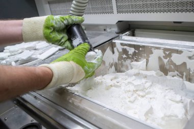 Mane, 3D yazıcının çalışma odasındaki beyaz polyamide tozundan modeller çıkarıyor, toz temizliyor ve kaldırıyor. Toz 3D yazıcıda model oluşturma süreci. Çoklu Jet Füzyon MJF. İşçi elleri