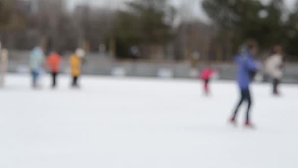 冬天人们在溜冰场上滑冰 模糊的背景 休闲娱乐周末度假过冬活动的生活方式 公共城市冬季娱乐享乐 — 图库视频影像