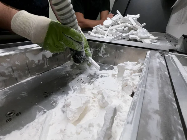 Mane taking out models from white polyamide powder in working chamber of 3D printer, cleaning and removes powder. Process of creating model on powder 3D printer. Multi Jet Fusion MJF. Worker hands