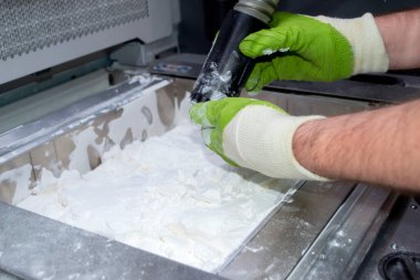 Mane, 3D yazıcının çalışma odasındaki beyaz polyamide tozundan modeller çıkarıyor, toz temizliyor ve kaldırıyor. Toz 3D yazıcıda model oluşturma süreci. Çoklu Jet Füzyon MJF. İşçi elleri