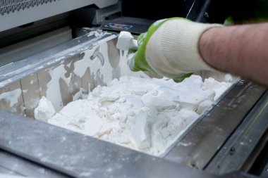 Mane, 3D yazıcının çalışma odasındaki beyaz polyamide tozundan modeller çıkarıyor, toz temizliyor ve kaldırıyor. Toz 3D yazıcıda model oluşturma süreci. Çoklu Jet Füzyon MJF. İşçi elleri