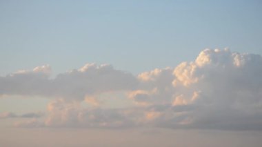 Gökyüzünde hızlı hareket eden bulutlar. Gün batımında mavi gökyüzünde hızlı hareket eden beyaz yağmur bulutları. Doğal arka plan. Hava bulutlu. Bulutlar. Hava manzarası. Doğa arkaplanı Cumulus bulutları arkaplanı bulanıklaştırdı