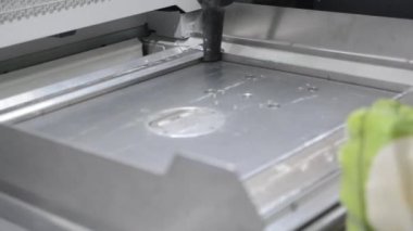 Bir erkek işçi, elektrikli süpürgeyle endüstriyel 3D yazıcının yüzeyini beyaz tozdan temizliyor. Çoklu Jet Füzyon MJF 3D baskı. Çalışma süreci