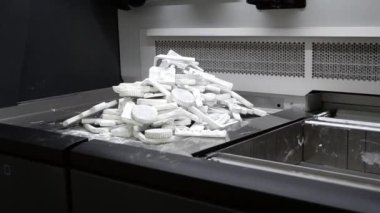 Detail objects printed on powder 3D printer and covered white polyamide powder close-up. Technology Multi Jet Fusion MJF. 3D prototype models created by new additive progressive 3d printing technology