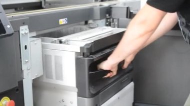 İşçi 3D yazıcının çalışan kamerasını 3D yazıcıya taşır. Büyük endüstriyel 3D yazıcı, üretim laboratuarında poliyamit tozuyla basılıyor. Çoklu Jet Füzyonu. Endüstriyel