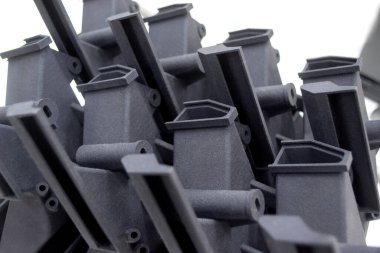 Laboratuvar ofisindeki 3D yazıcıya siyah model basılmış. Plastik kapaktan 3D yazıcıya basılmış nesne. 3D yazıcıda yapılmış bir prototip. Yeni modern baskı teknolojisi kavramı. Çoklu Jet Füzyonu