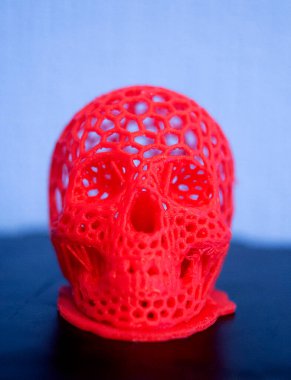 3D printed human skull prototype printed of red plastic close-up.
