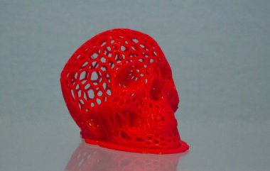 3D printed human skull prototype printed of red plastic close-up.