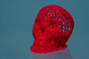 3D printed human skull prototype printed of red plastic close-up.