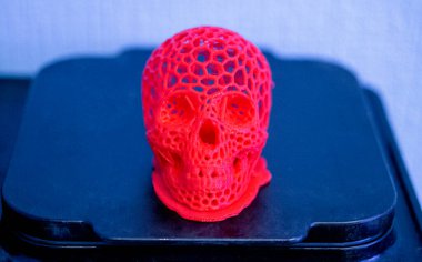 3D printed human skull prototype printed of red plastic close-up.