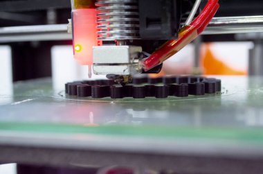 3d printer printing a model close-up. The process of printing a model on a 3D printer made of orange plastic. 3D printer working close up