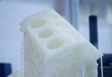 Object printed on 3D printer from plastic. The object a prototype of an automobile engine printed on a 3D printer from white plastic. 3D volumetric model. Concept new modern printing technology