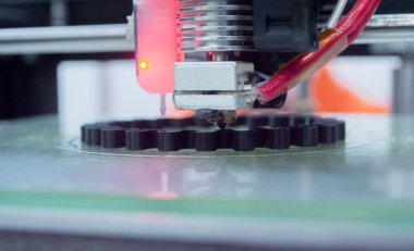 3d printer printing a model close-up. The process of printing a model on a 3D printer made of orange plastic. 3D printer working close up