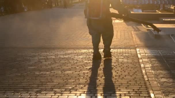 Man Airtight Suit Sprays Disinfecting Liquid Pavement Street City Backdrop — Vídeo de stock