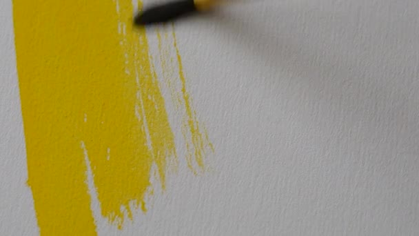 Person Applies Liquid Yellow Paint Brush White Canvas Close Man — Stockvideo