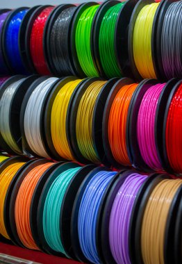 Many multi-colored spools of thread of filament for printing 3d printer. Material coils for printing 3D printer. Spools of 3D printing motley different colors filament. ABS wire plastic for 3d printer