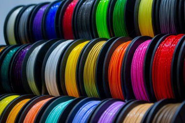 Many multi-colored spools of thread of filament for printing 3d printer. Material coils for printing 3D printer. Spools of 3D printing motley different colors filament. ABS wire plastic for 3d printer