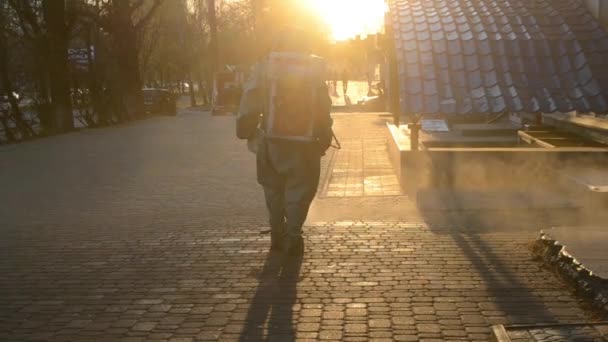Man Airtight Suit Sprays Disinfecting Liquid Pavement Street City Backdrop — Vídeo de Stock