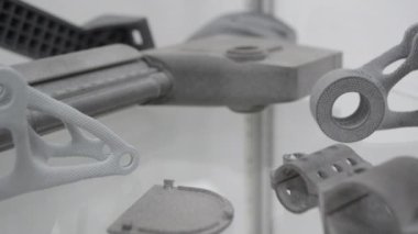 3D yazıcıdan diğer modellere 3 boyutlu yazıcı kapsama alanına giren kişi. Teknoloji MJF. 3D yazıcıya üç boyutlu gri renkli nesne basıldı. Modern yenilik teknolojisi