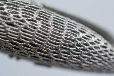 Metal yakın çekim makrosu için 3D yazıcıya basılmış. Metal 3D yazıcıya basılmış üç boyutlu model. Metal için basılı lazer sinterleme makinesi. Biçim seçici lazer erimesi ile yazdırıldı