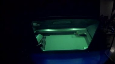 Working 3d printer for metal. 3D printer printing object from metal powder in working chamber by sintering metal powder under laser. SLM. Selective laser melting technology. Melting metal powder