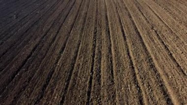 Landscape of plowed up land on an agricultural field on a sunny autumn day. Flying over the plowed earth with black soil. Black soil. Ground earth dirt priming aerial drone view. Agrarian background